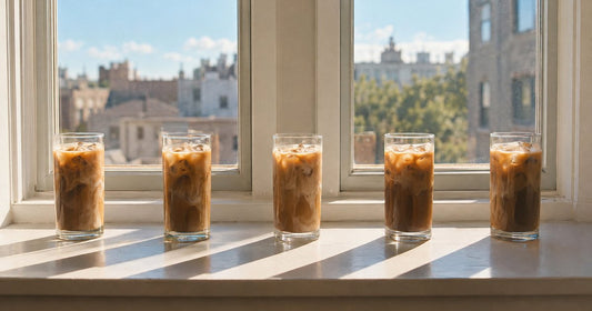 Five identical glasses of iced coffee in a row, representing daily use